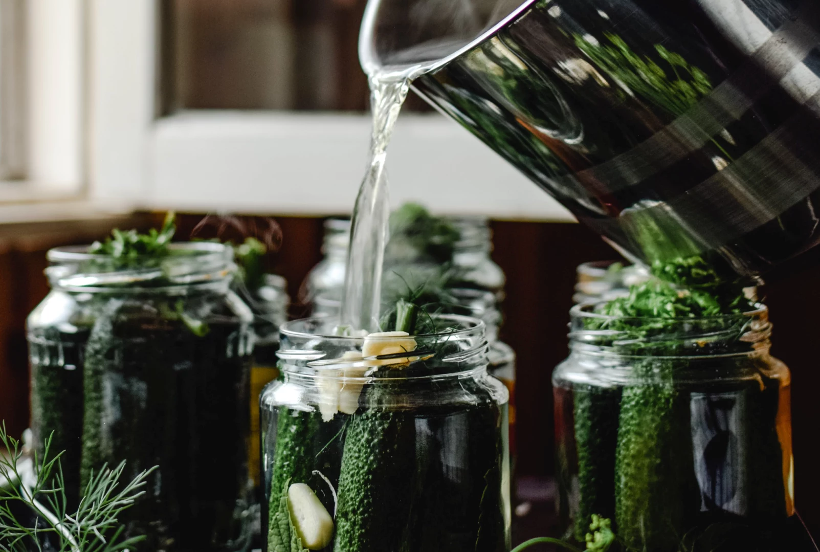 Brine being poured into pickle jars